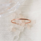 Rose gold women's finger ring on a soft white blurred crystal and fabric background