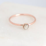 Minimalist cremation ring featuring a small, round, cabochon setting in rose gold fill on a light background.