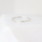 Slim sterling silver women's finger ring on a light gray background. The ring has a uniformly hammered or scalloped finish.